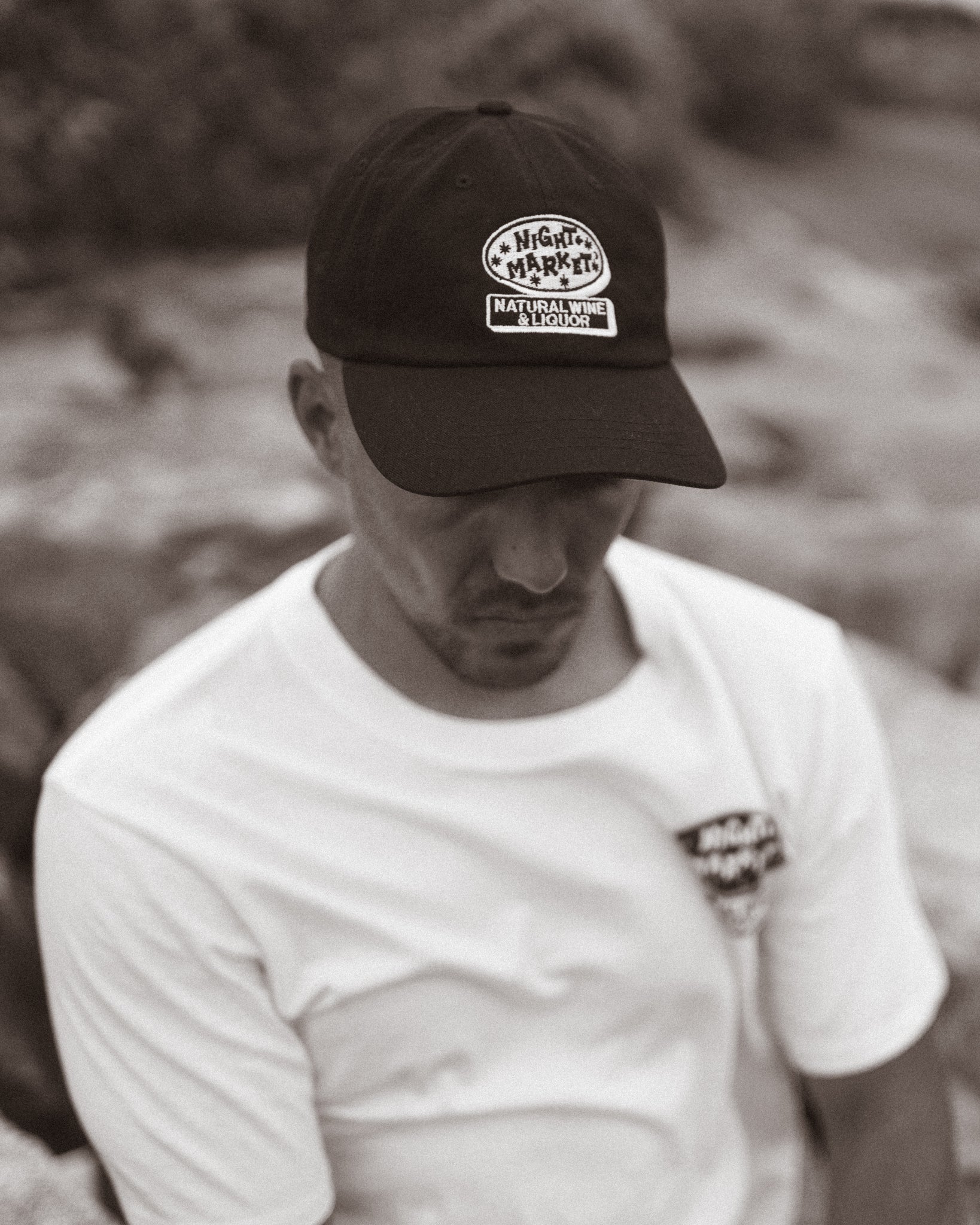 Guy wearing a Night Market restaurant baseball hat and Night Market restaurant t-shirt.